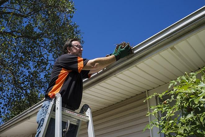 repairman sealing and reattaching a loose and sagging gutter in Jackson, WI